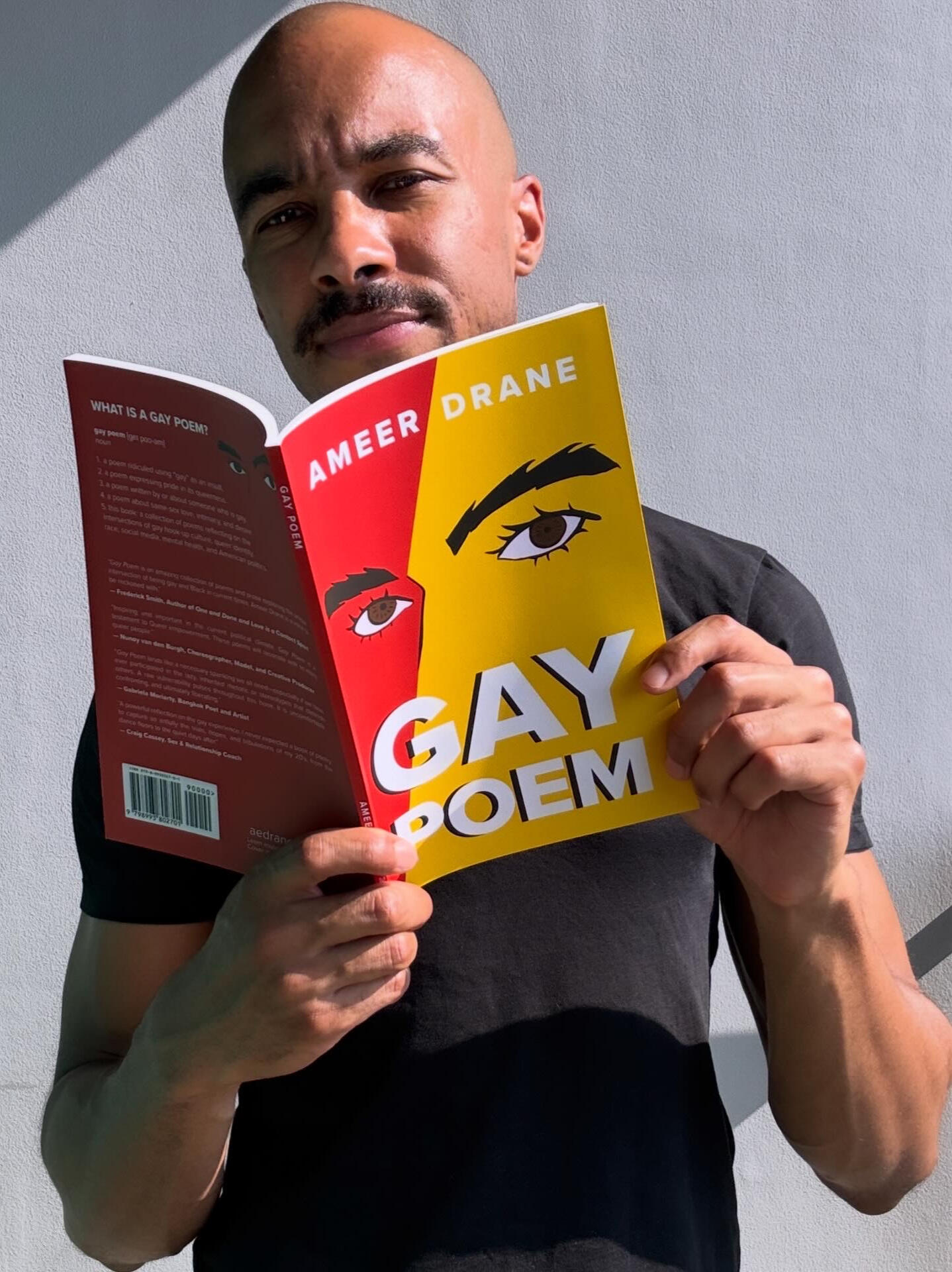 Gay Poem Ameer Drane Image of Ameer Drane holding his gay poetry book, Gay Poem.